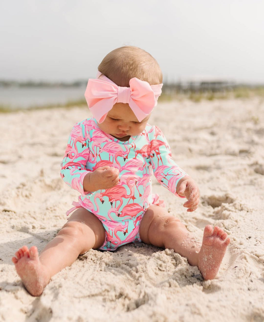 RuffleButts Baby Girls UPF 50+ Sun Protection Tropical Print Long Sleeve One Piece Rash Guard Swimsuit with Zipper - Fab Flamingo, 3-6m