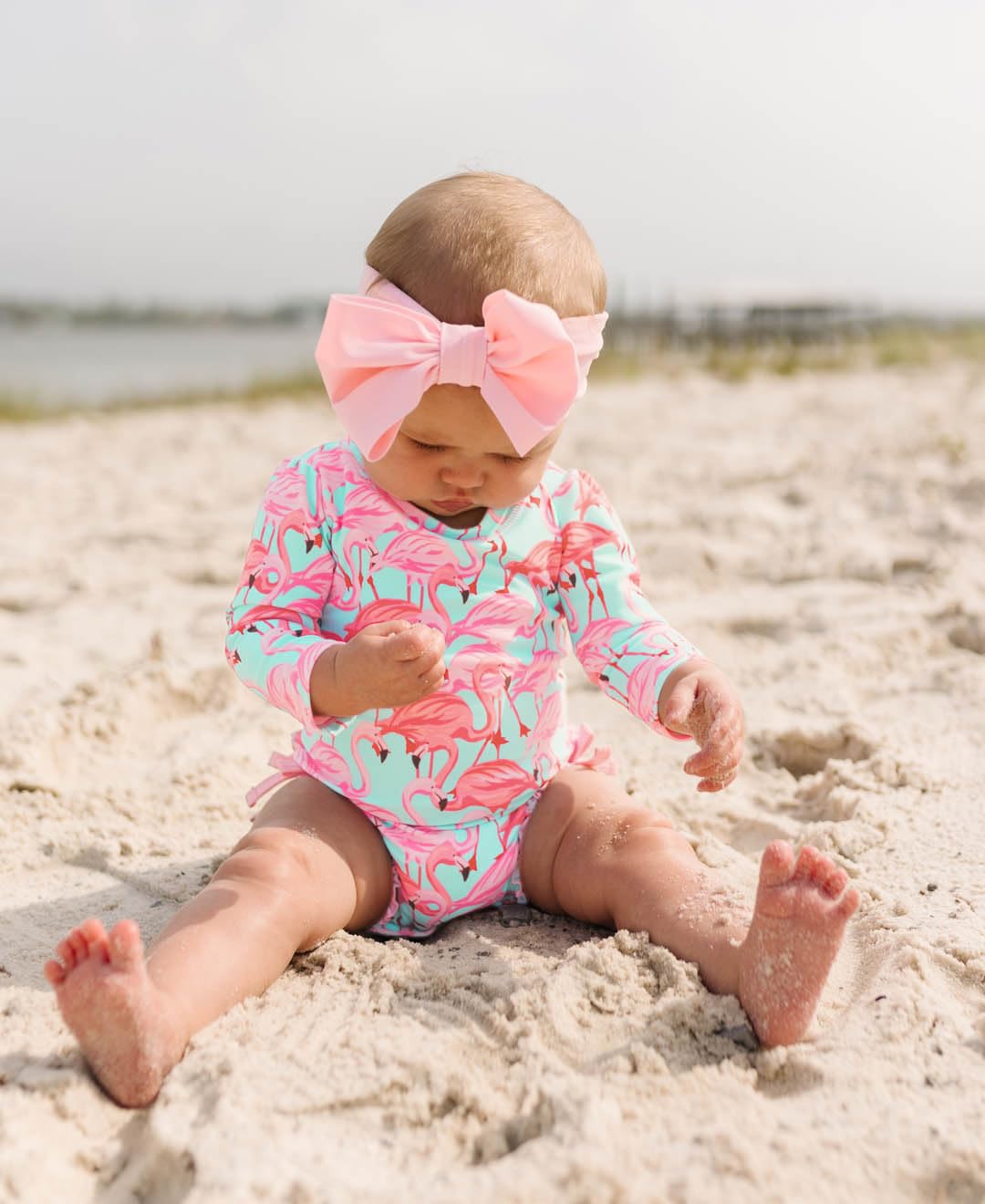 RuffleButts Baby Girls UPF 50+ Sun Protection Tropical Print Long Sleeve One Piece Rash Guard Swimsuit with Zipper - Fab Flamingo, 3-6m