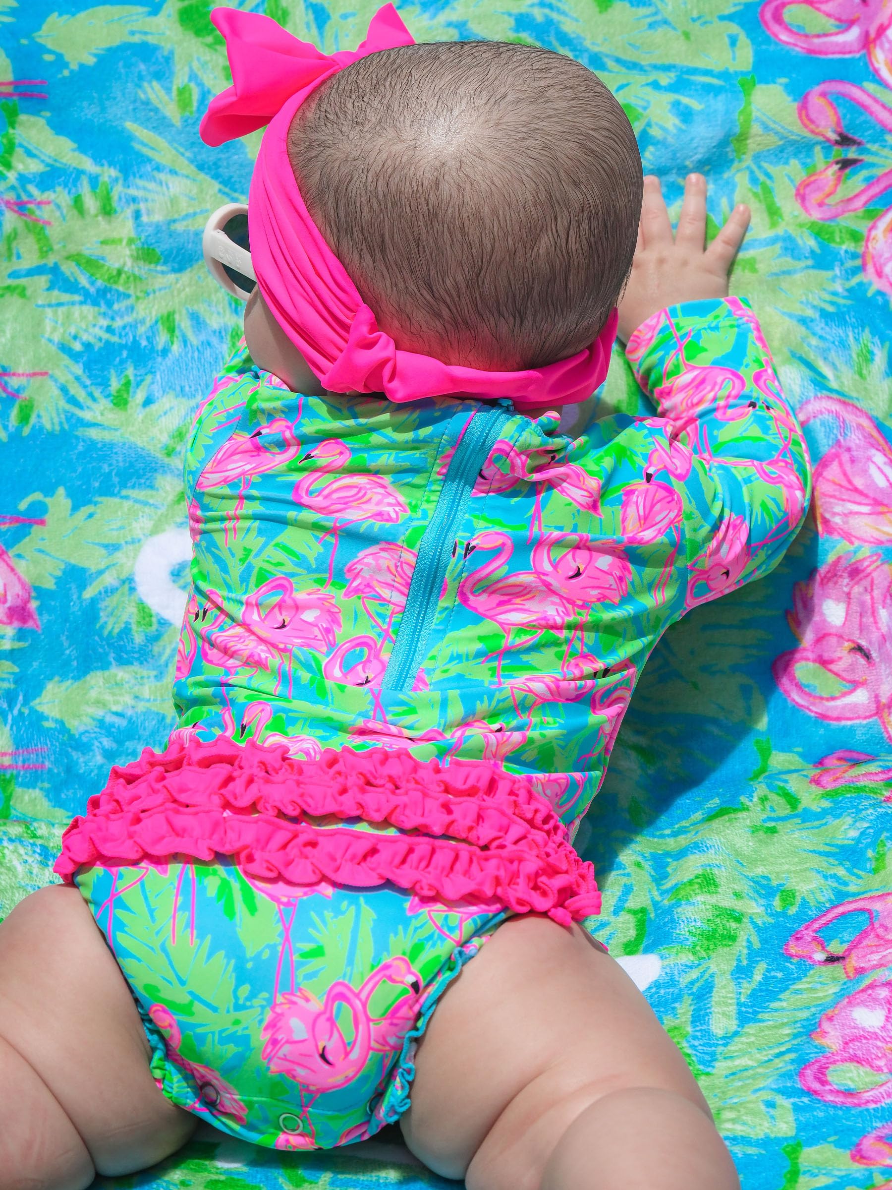 RuffleButts Baby Girls UPF 50+ Sun Protection Tropical Print Long Sleeve One Piece Rash Guard Swimsuit with Zipper - Neon Flamingo Fun, 12-18m